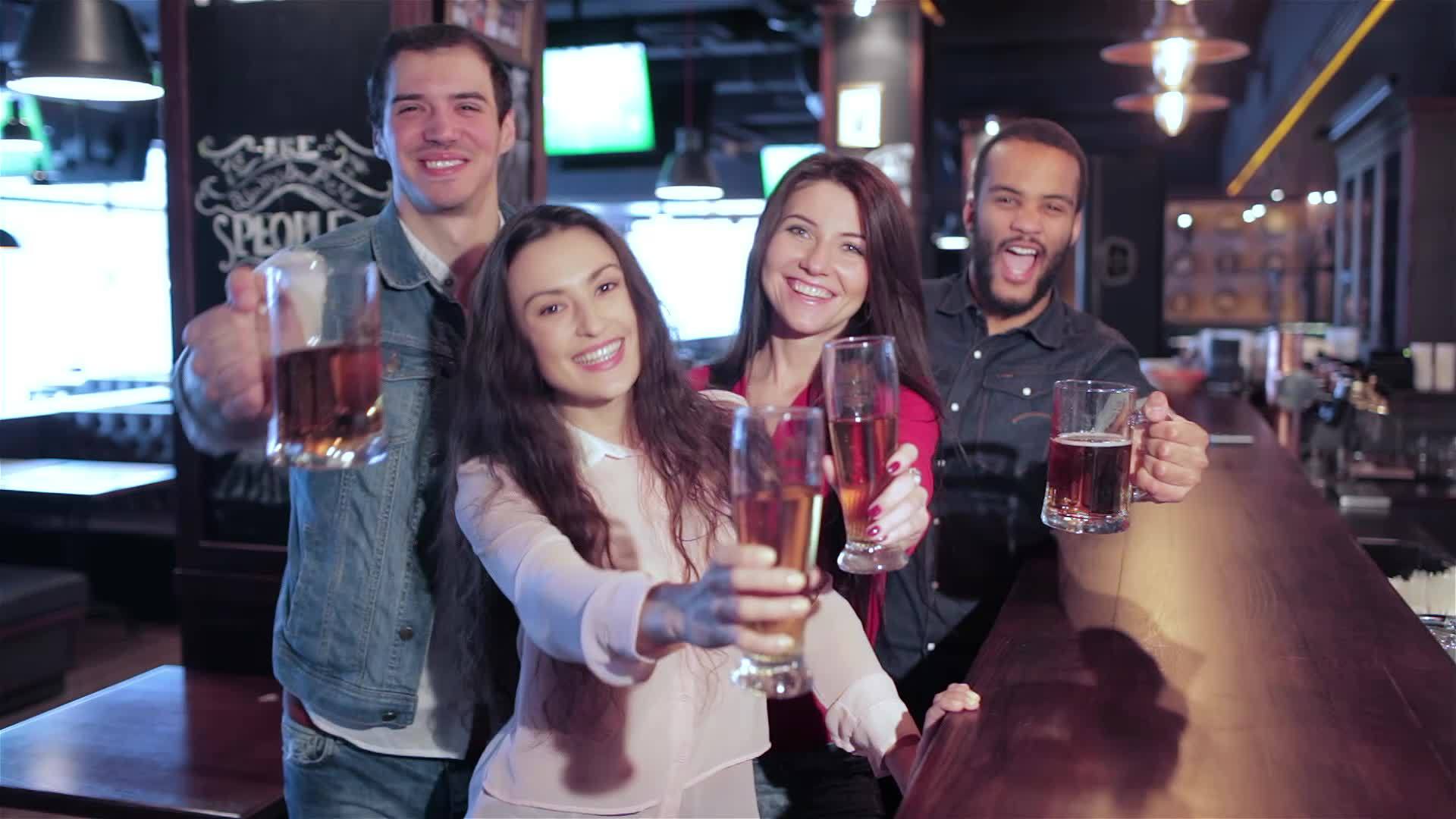 四个在酒吧喝啤酒的老朋友欢迎新朋友参加视频的预览图