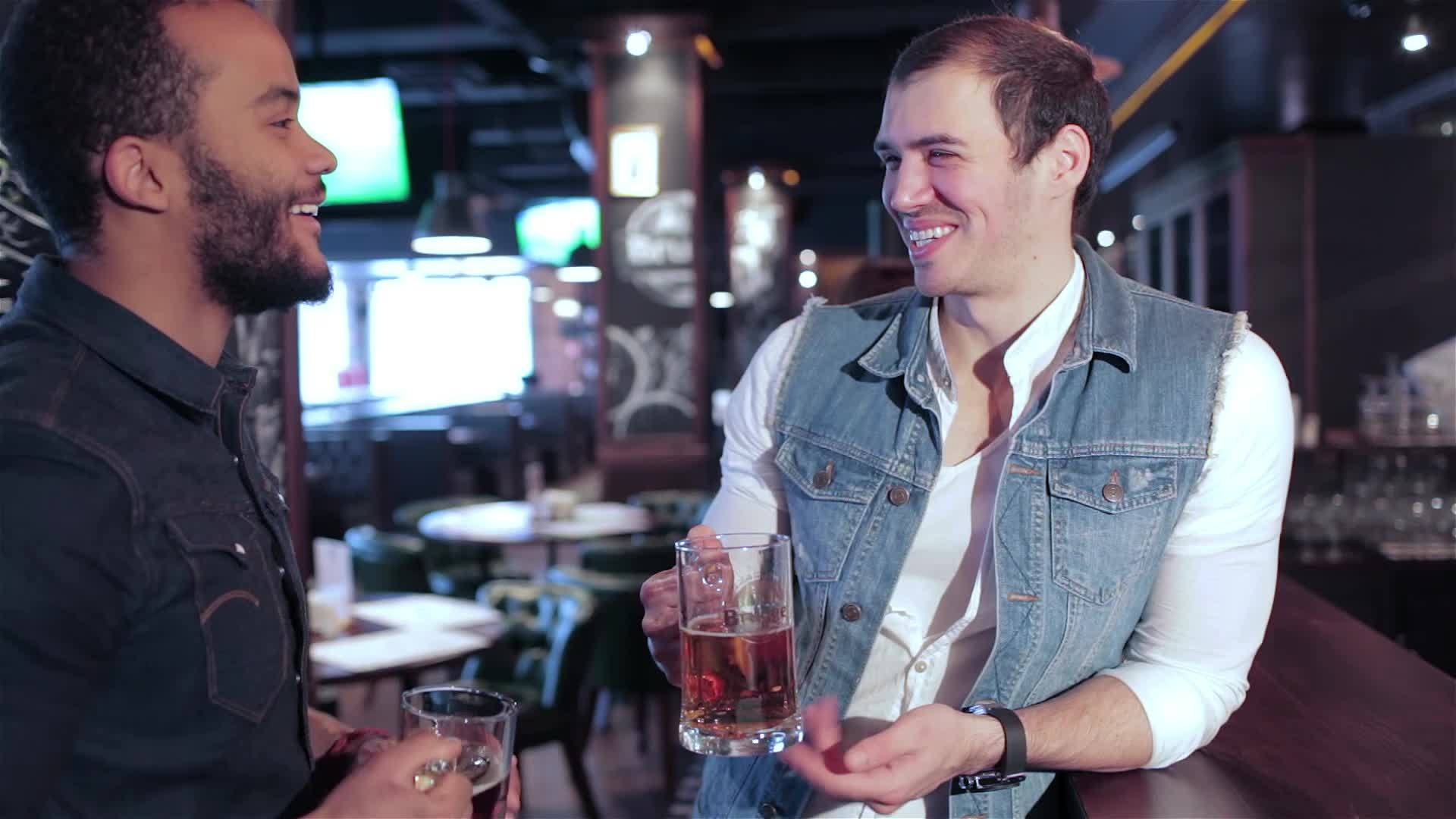 两个朋友在酒吧里拿着啤酒杯戒指视频的预览图