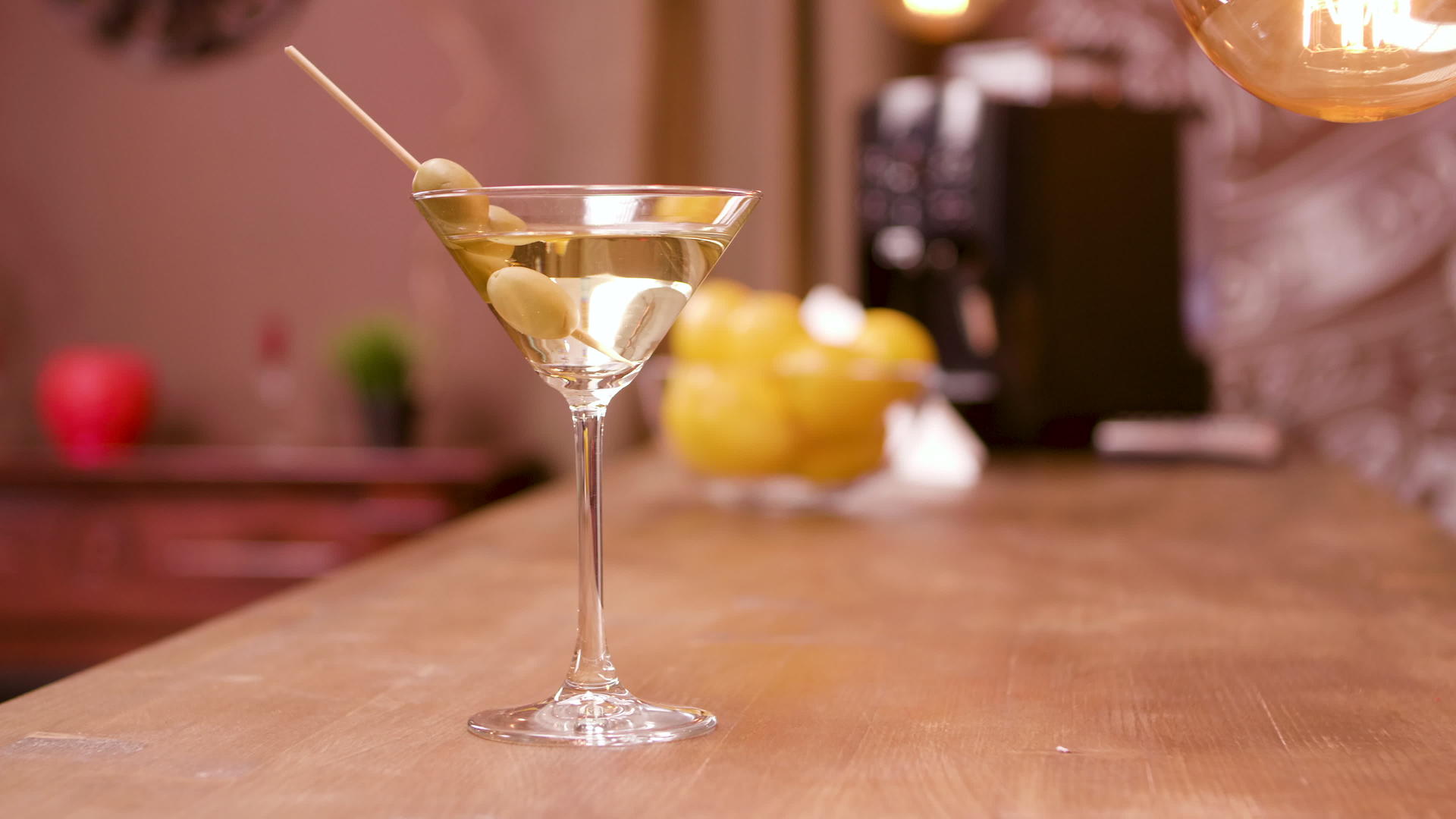 马提尼鸡尾酒杯在酒吧柜台加入橄榄视频的预览图
