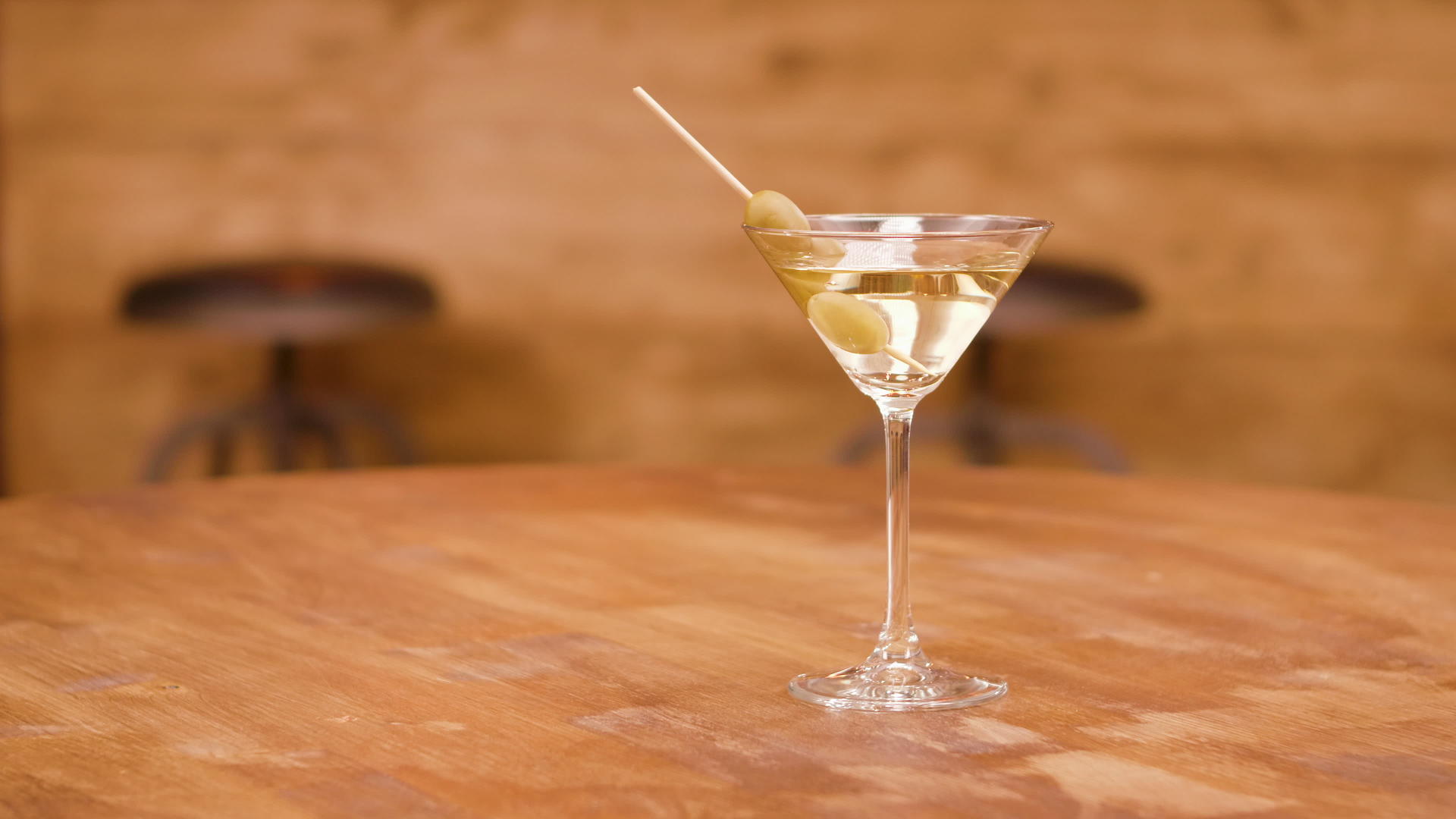 一杯马提尼酒杯在空木桌子上视频的预览图