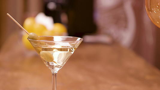 在酒吧的柜台上一杯绿橄榄在马提尼酒杯里视频的预览图