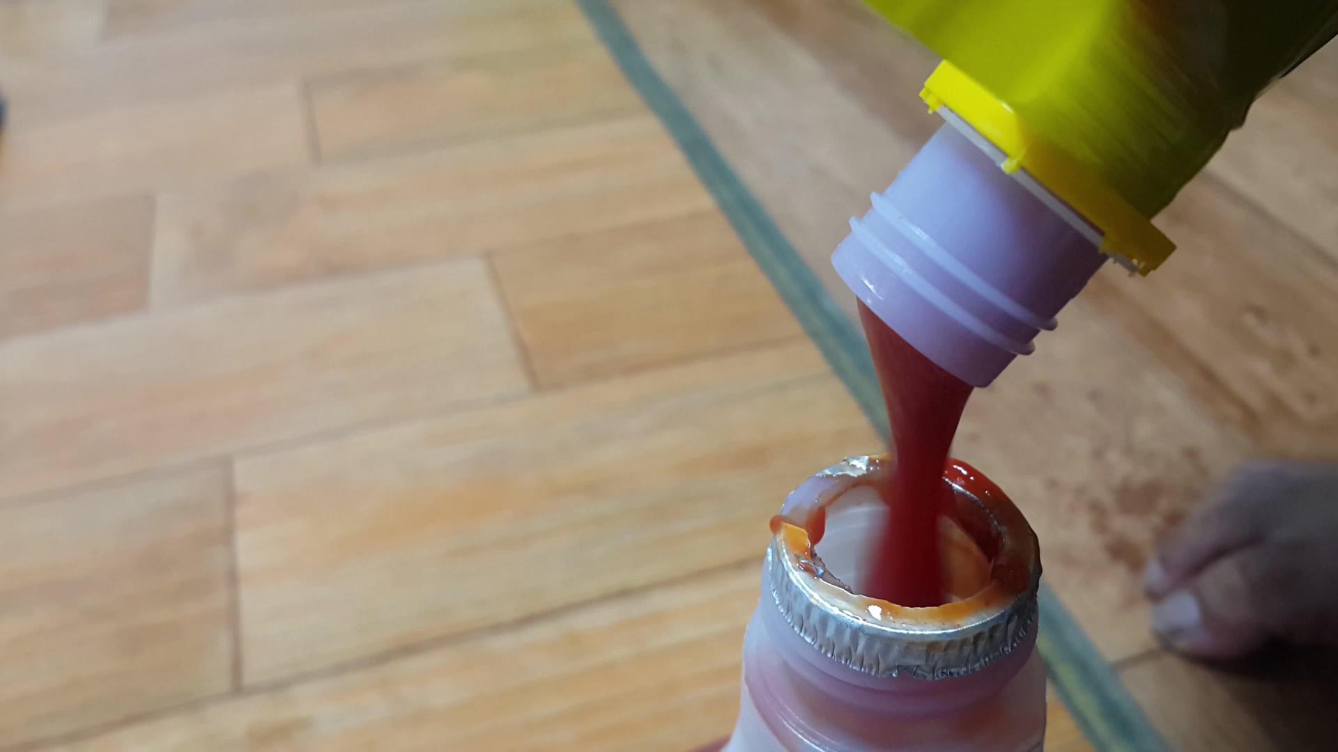 红番茄番茄酱从黄瓶子里倒入小瓶子里视频的预览图