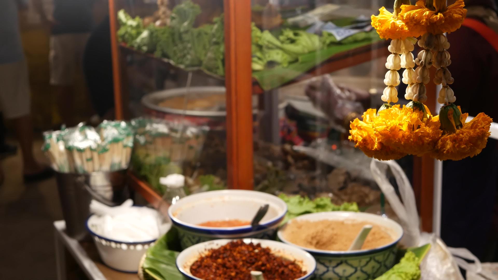 泰国街头美食广场的摊位上摆满了带有传统亚洲酱汁的碗视频的预览图
