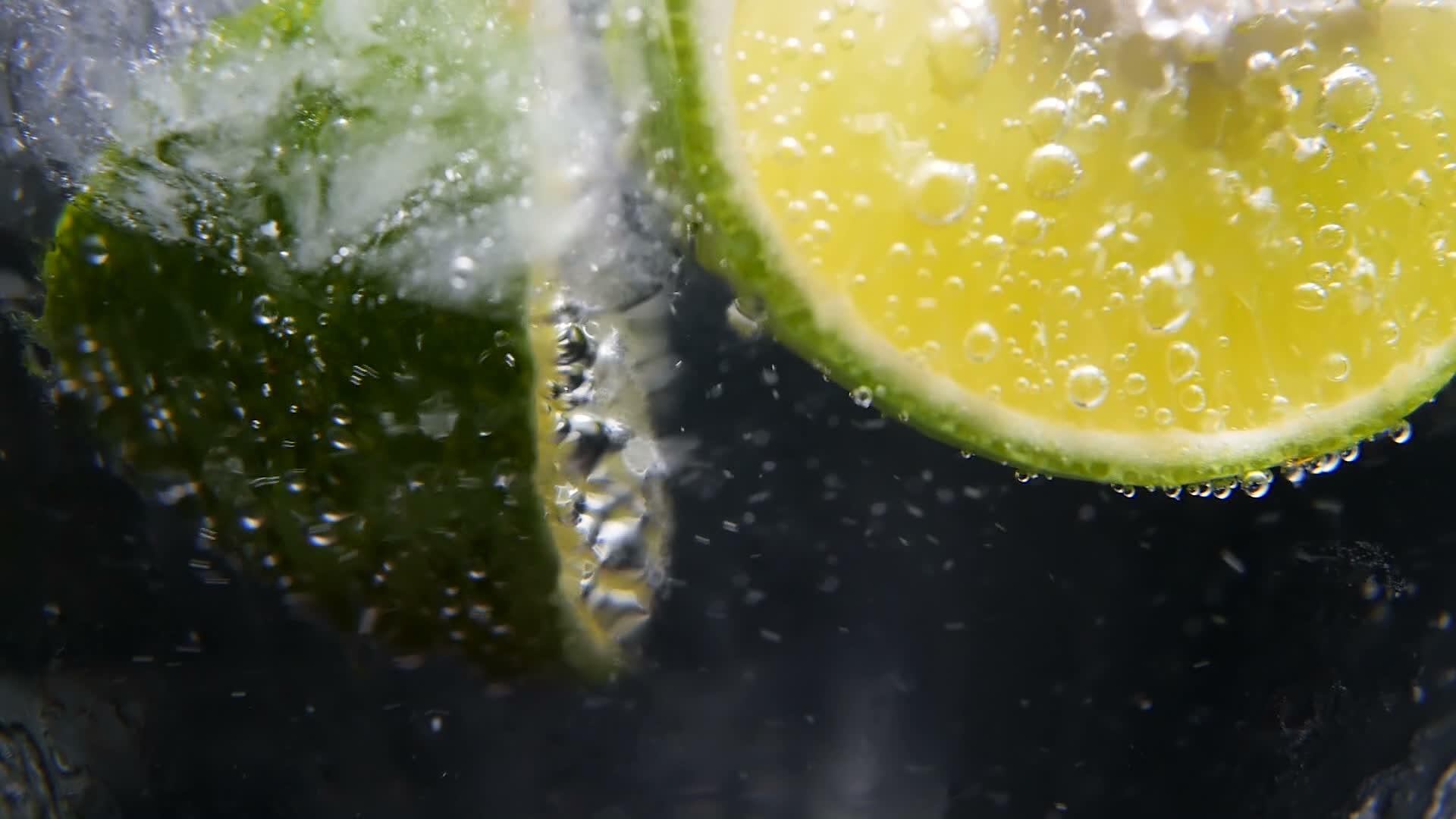 健康饮食营养冷柠檬水酸橙饮料黑色背景视频的预览图