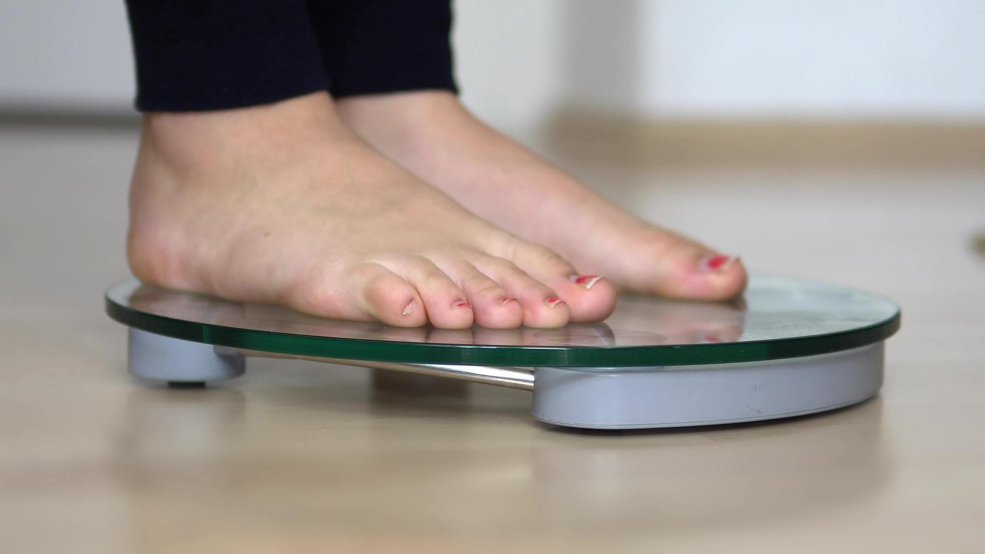 女人的脚站在体重秤上视频的预览图