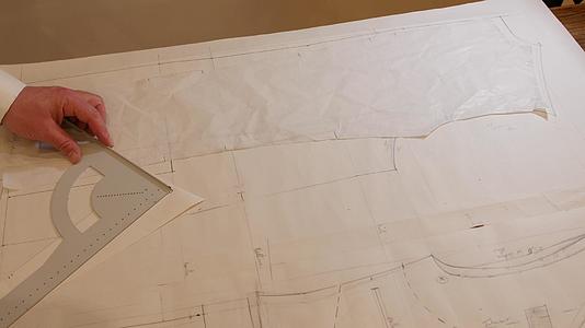专业裁缝在工作室的纸上画西装图案来测量和绘制图案视频的预览图