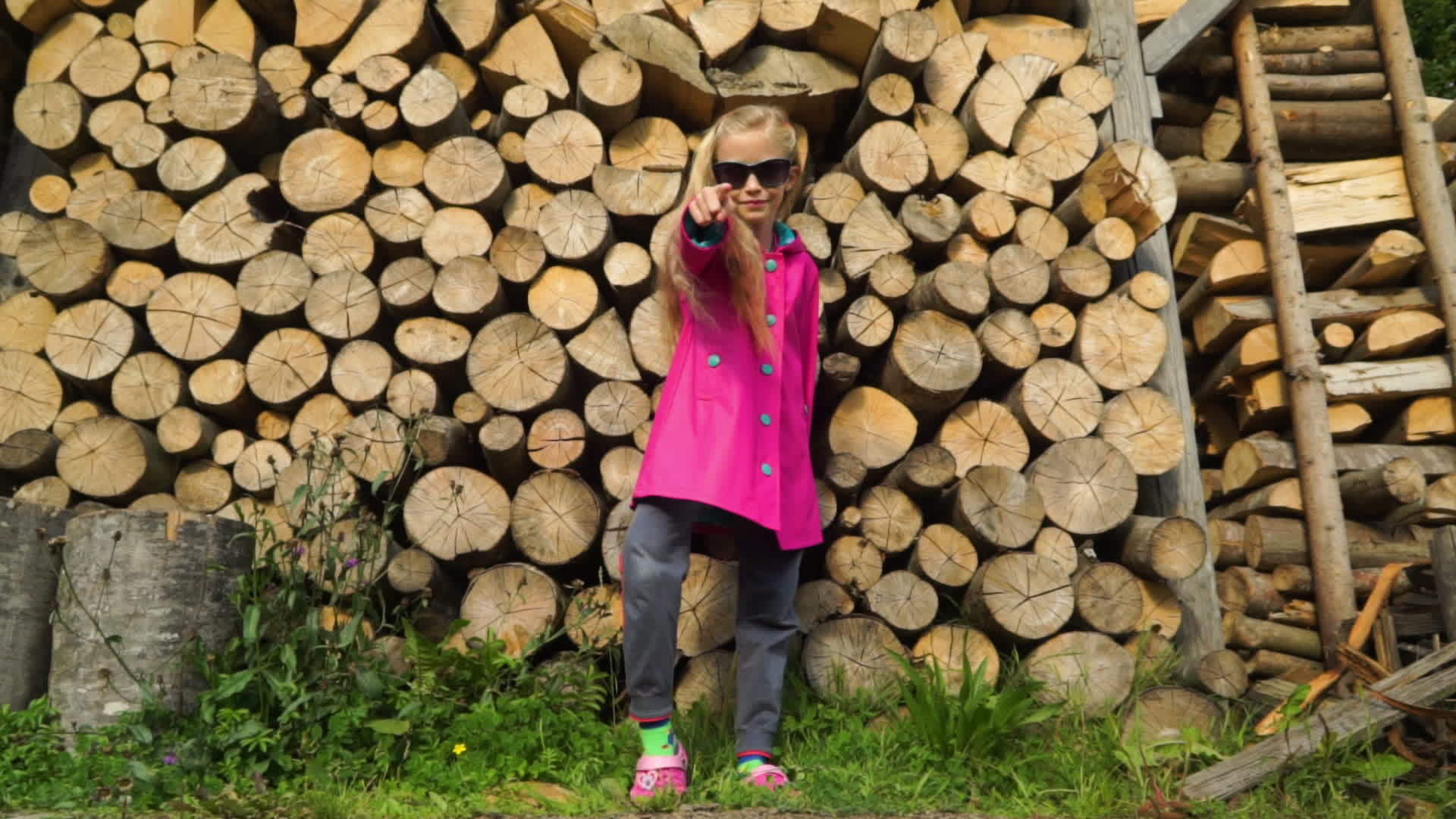 迷人的乡村女孩穿着粉色外套和太阳镜手里拿着背景堆叠视频的预览图