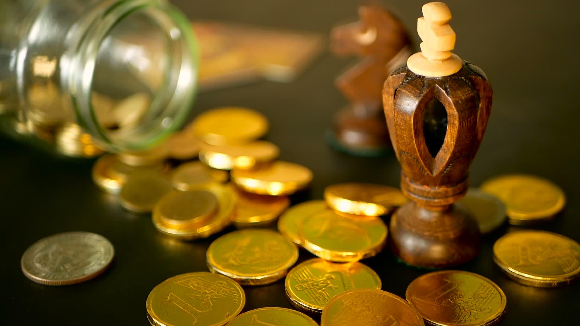 黑色桌子上的金币和旋转便士黄色硬币从罐子里掉了下来视频的预览图