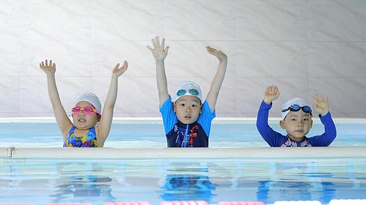 暑假里小朋友在游泳池培训欢乐的挥手