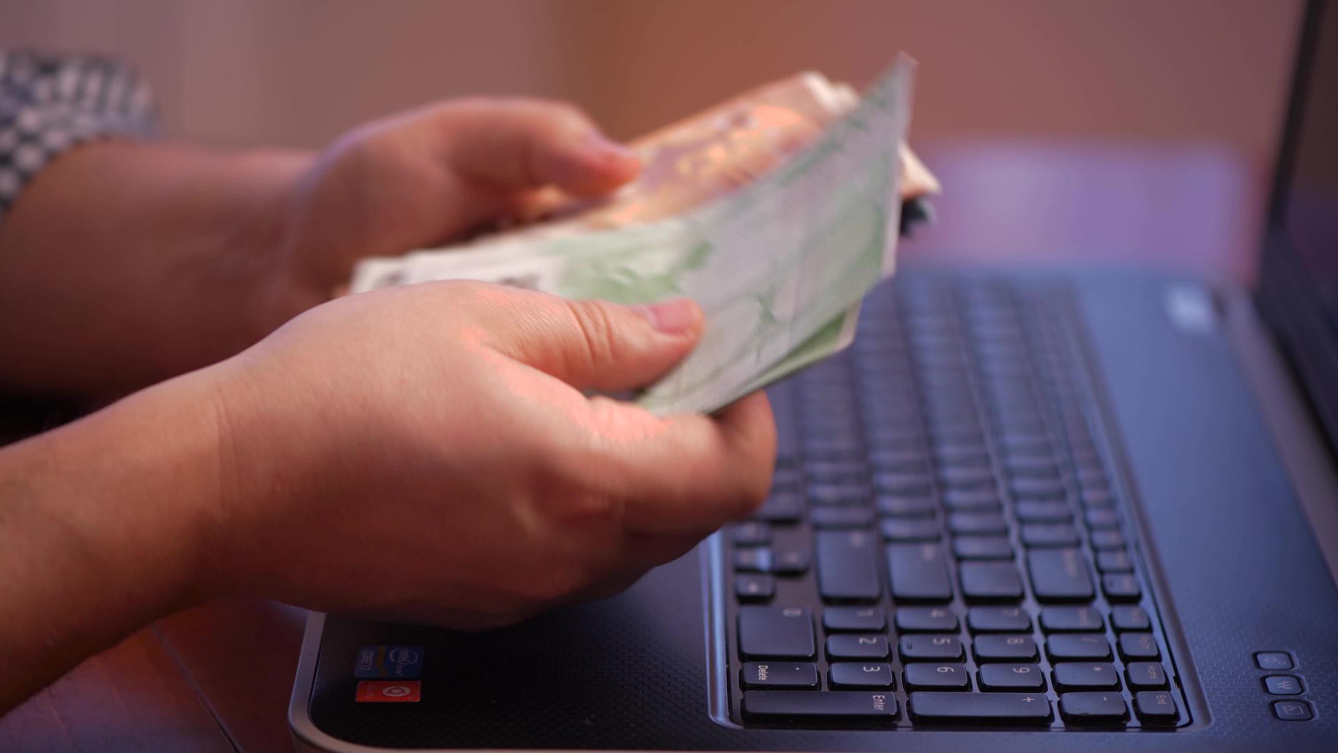 一个人坐在电脑前数着网上赚的钱视频的预览图