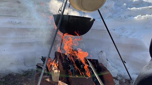 一个旅游锅挂在冬天的火上 在冬天用大自然的火做饭视频的预览图