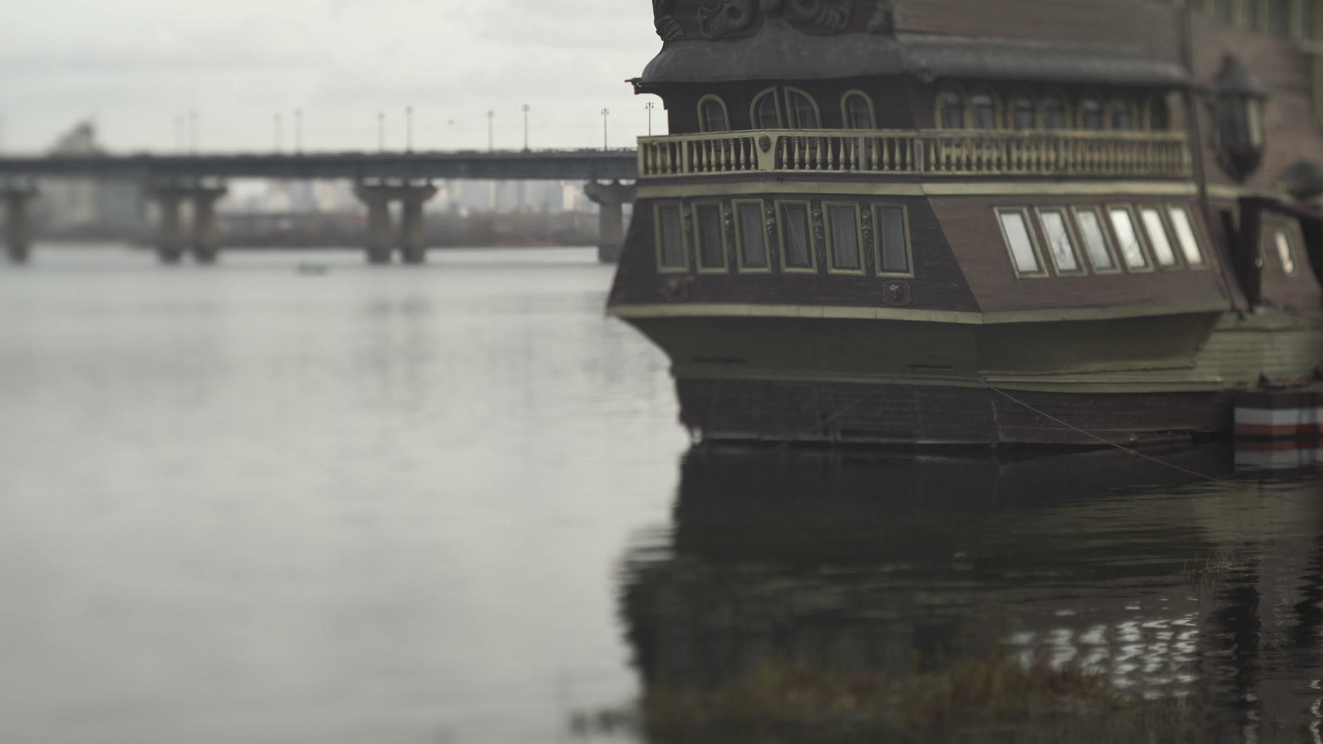 一艘小渔船停在桥边的河上港口视频的预览图