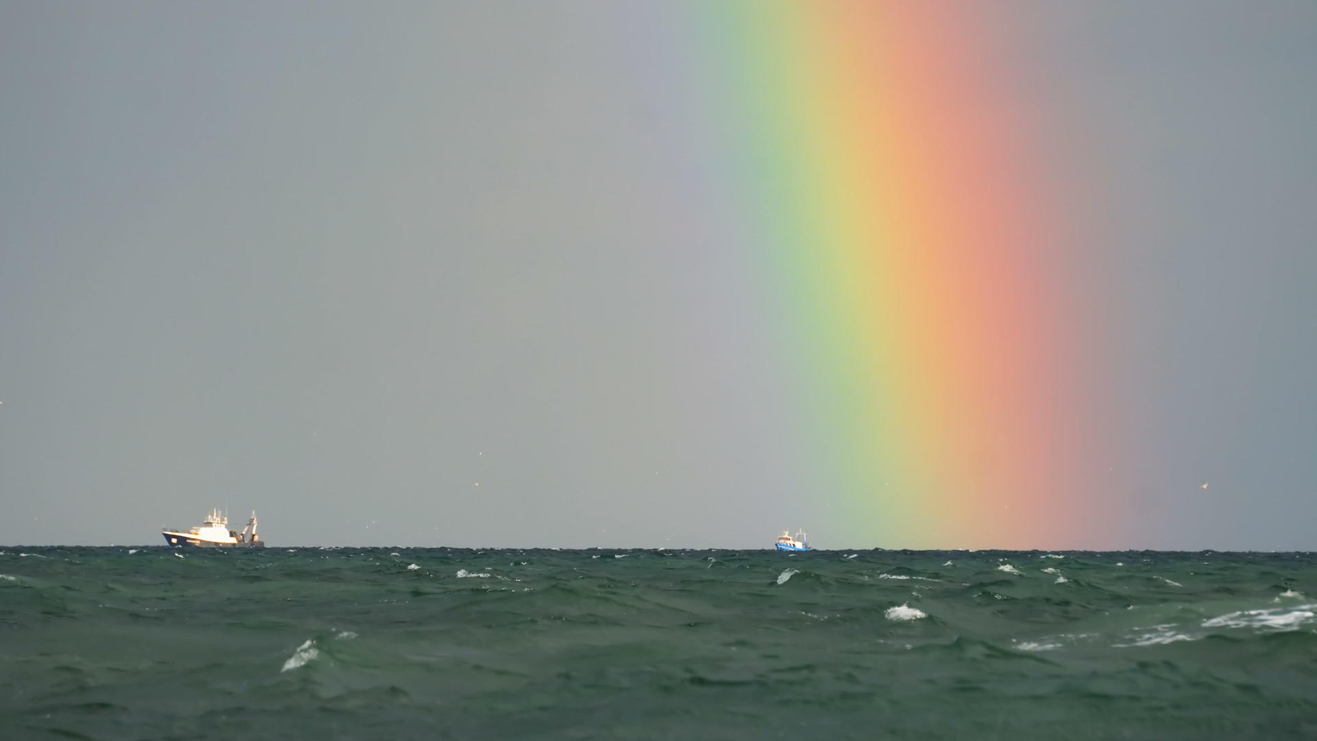 在大海上的彩虹海洋上有船在海平线上视频的预览图