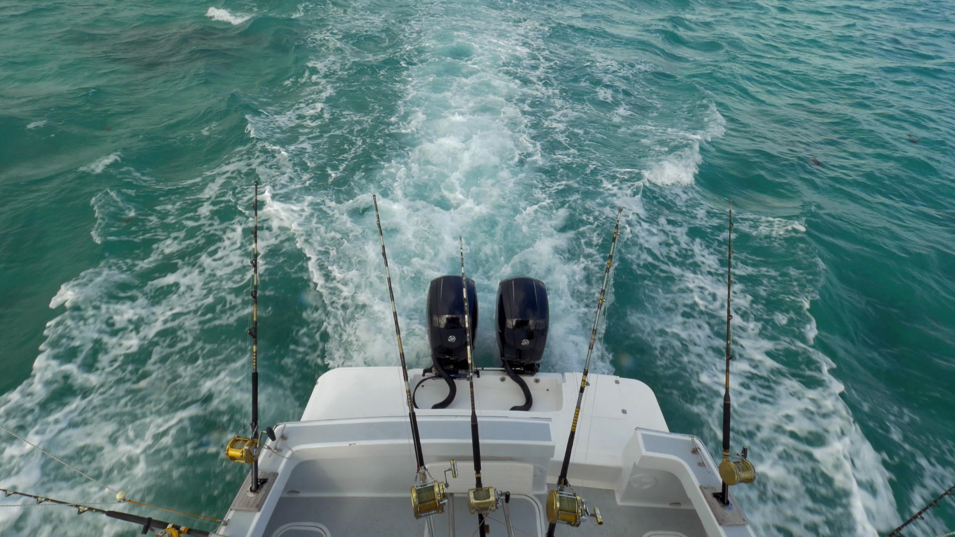 悬挂鱼钩的机动渔船在海上航行视频的预览图