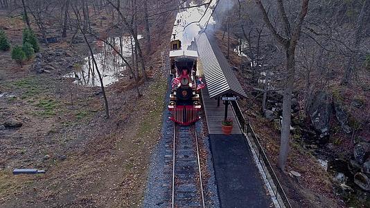从空中俯瞰恢复的蒸汽机车和公共汽车在火车前面行驶视频的预览图