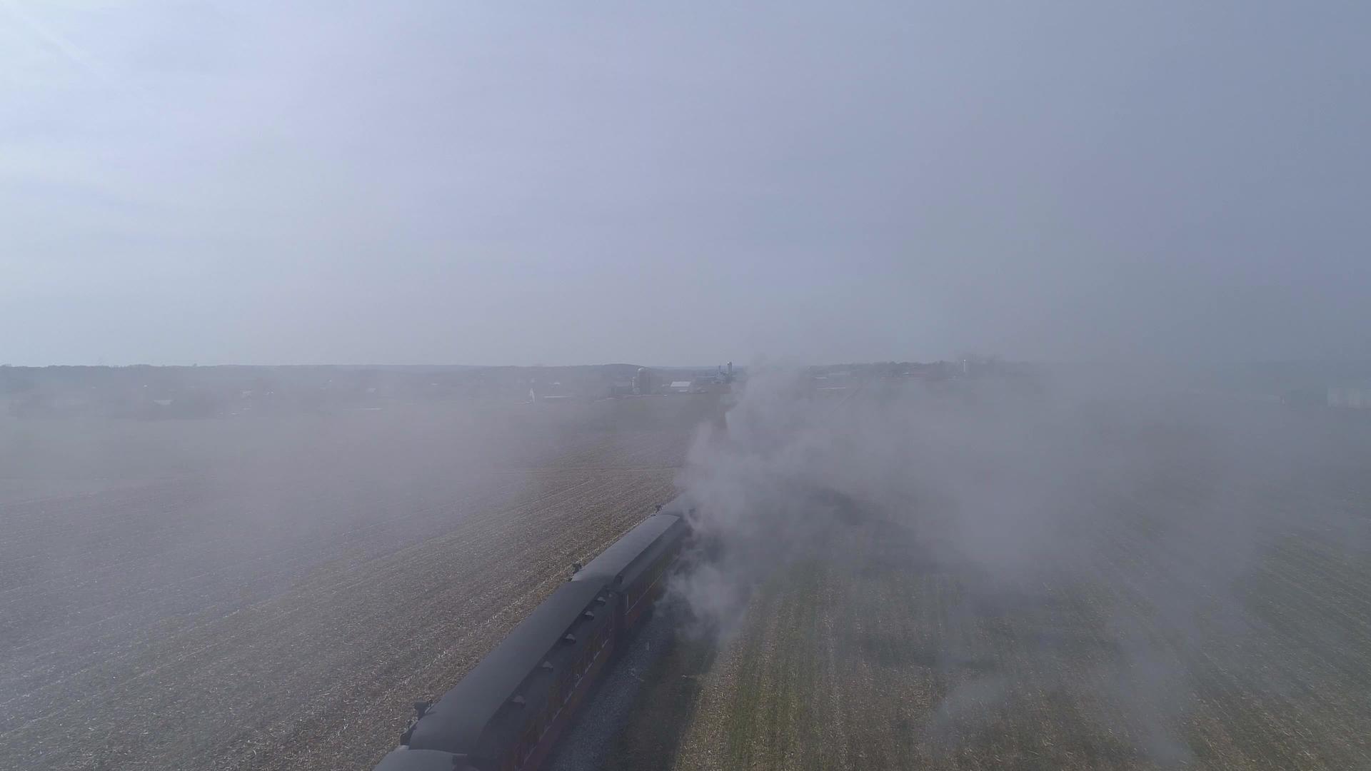 通过修理后的蒸汽机车和公共汽车的烟雾鸟瞰图公共汽车在火车后面视频的预览图