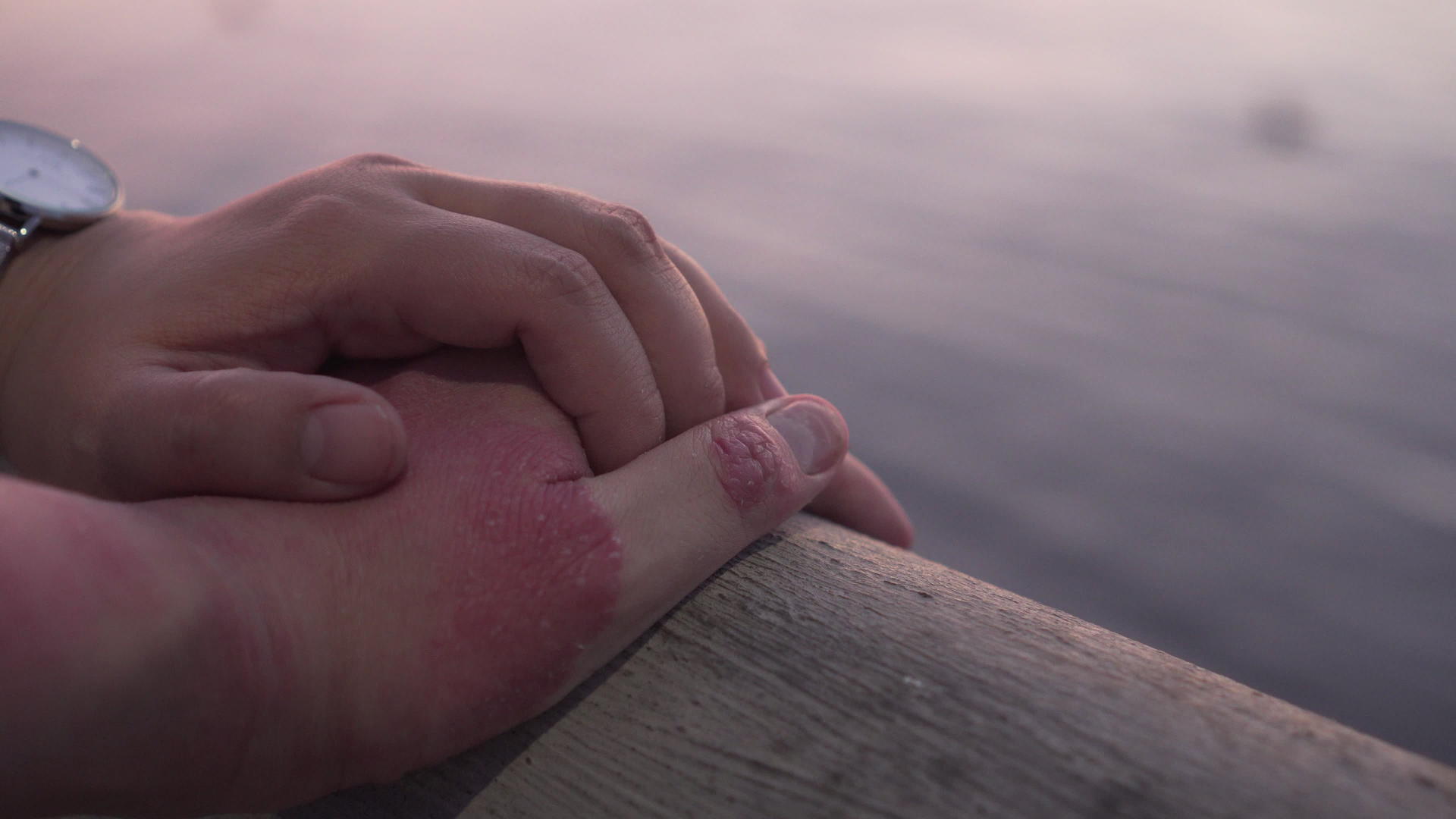 一对夫妇手牵着手感受着温暖的感觉感受着大海的日落和背景视频的预览图