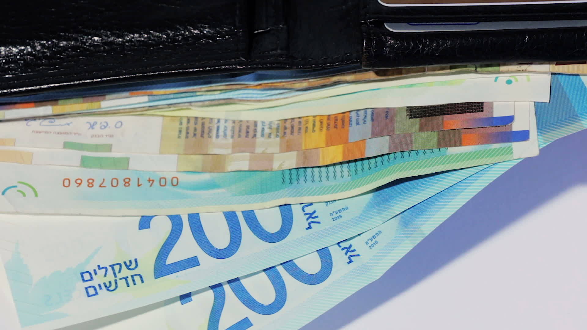 在开放的黑色皮夹中旋转各种Israeli谢克尔钞票最高视频的预览图