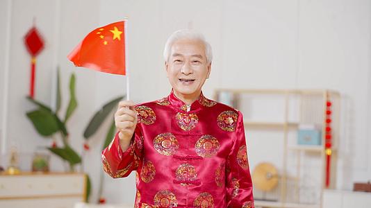 4k穿中国装扮的爷爷挥舞红旗视频的预览图