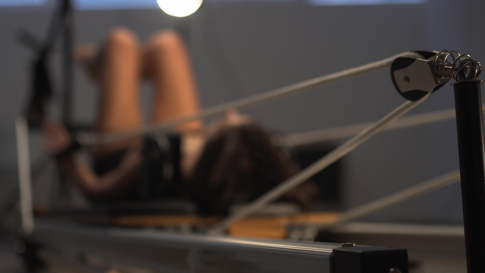 强壮的年轻女性在飞盘改造机上锻炼在紧张的弹簧上移动视频的预览图