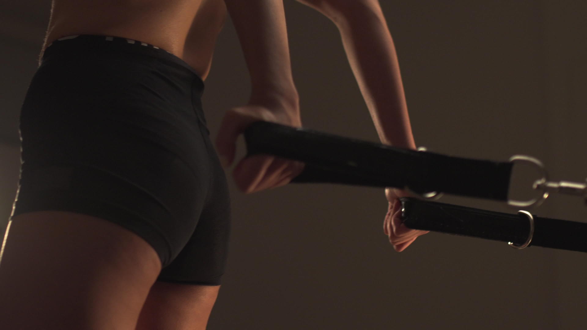 身体强壮的年轻运动女用腰带在紧张的弹簧上移动平台视频的预览图