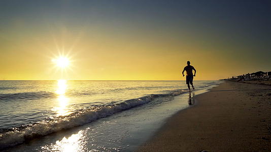一个年轻人在日落时在海边慢跑视频的预览图