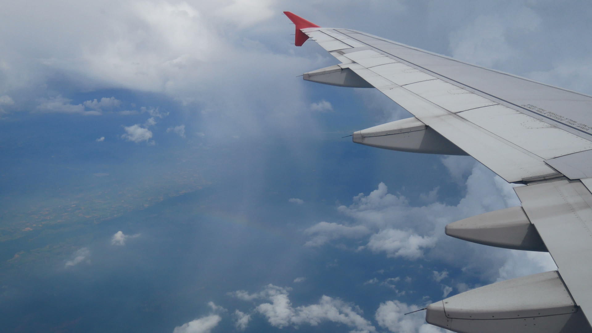 镜头通过飞机窗口的鸟瞰图飞机和美丽的白云飞越彩虹视频的预览图
