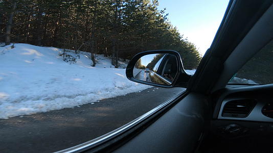 驾驶员射击驾驶员视角下雪时在路上行驶的镜头从后视镜上看视频的预览图