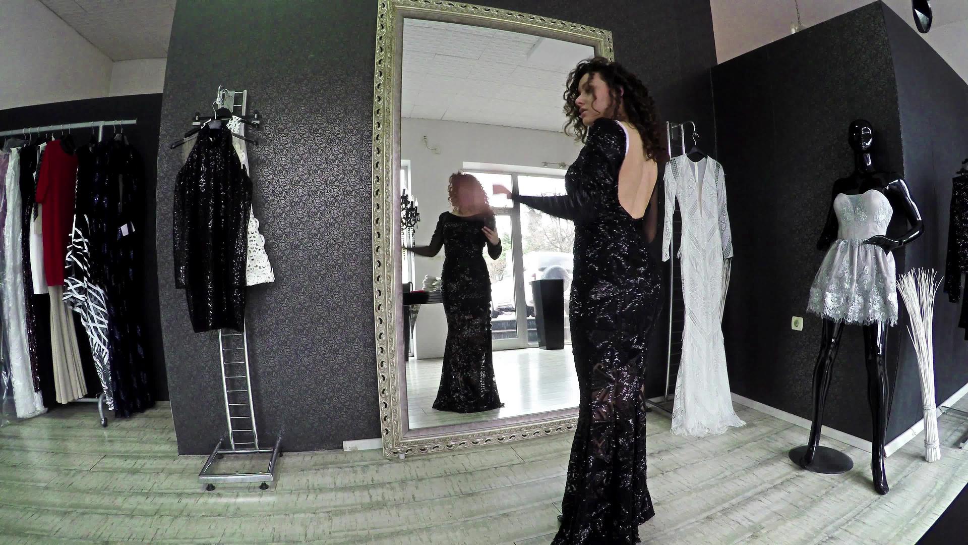 试图在时装裁缝工作室的镜子旁边穿衣服的漂亮美女视频的预览图