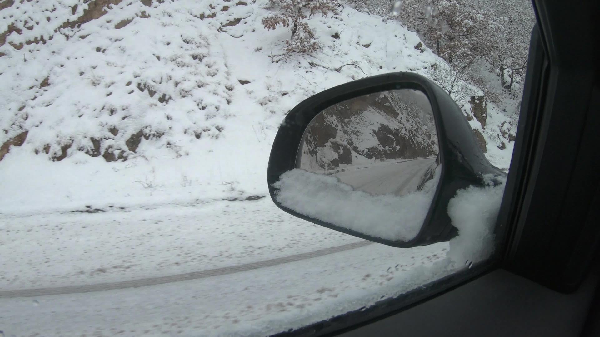 驾驶员射击驾驶员视角下雪时在路上行驶的镜头从后视镜上看视频的预览图