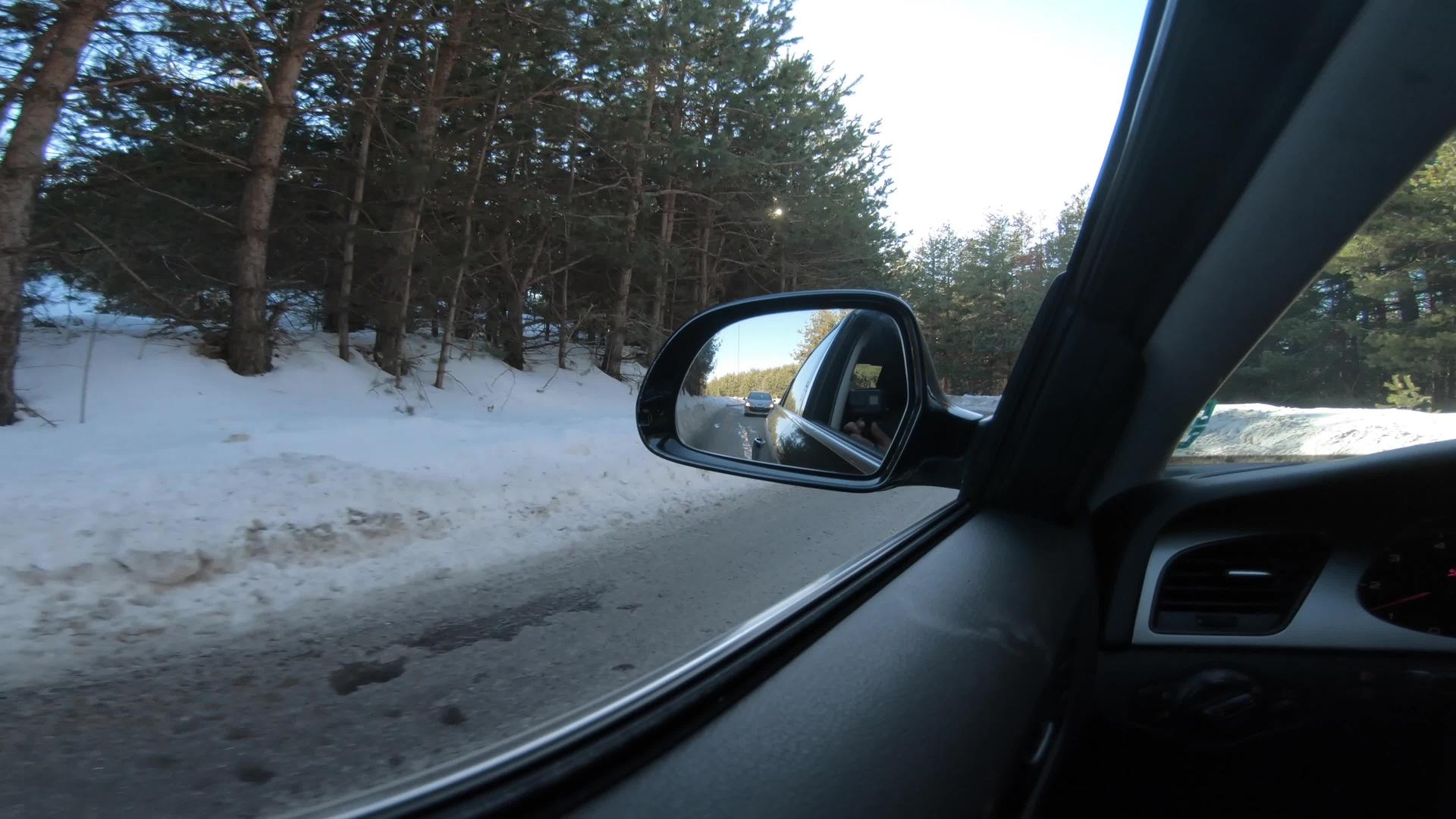 冬天在雪地里开车在雪地覆盖的雪山路上行驶视频的预览图