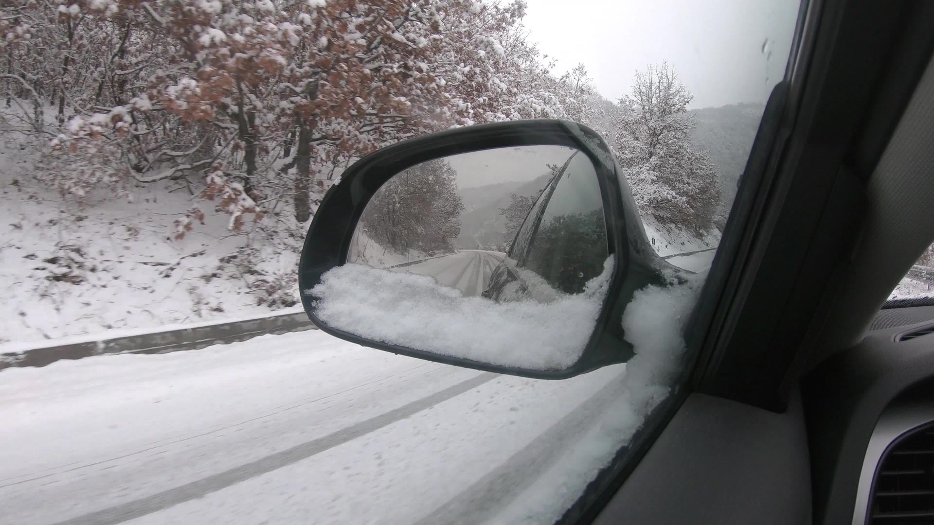 冬天在雪地里开车在雪地覆盖的雪山路上行驶视频的预览图