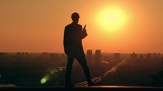 日出时男性建筑师戴着硬帽工作视频的预览图