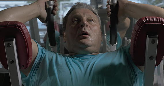 一名男子在健身房穿着蓝色衬衫在上腹部锻炼视频的预览图