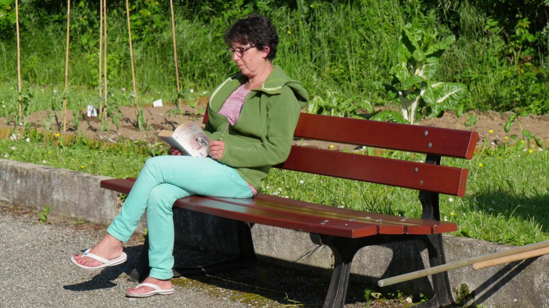 坐在长凳上看书的女人视频的预览图