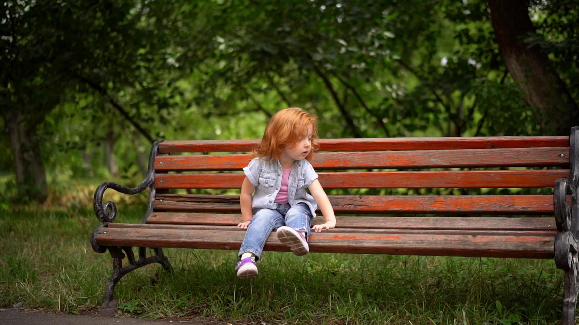 可爱的小女孩坐在长凳上视频的预览图