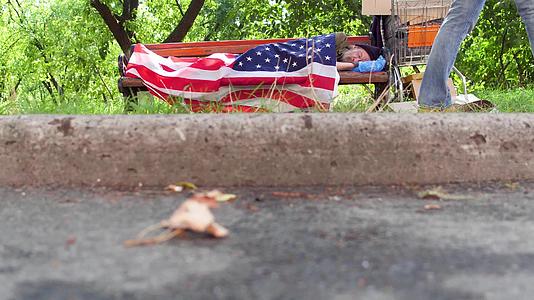 看到一个无家可归的人睡在街上的长椅上视频的预览图