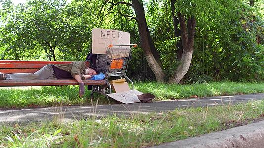 看着老乞丐睡在城市公园的长椅上视频的预览图