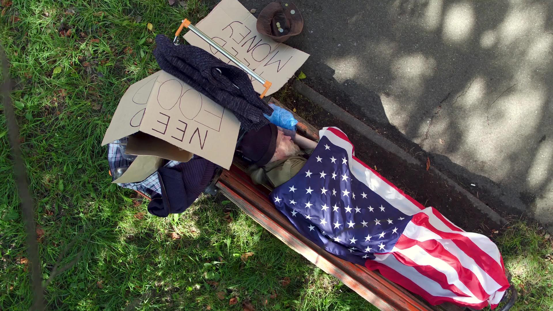 流浪汉睡在街上的长椅上视频的预览图