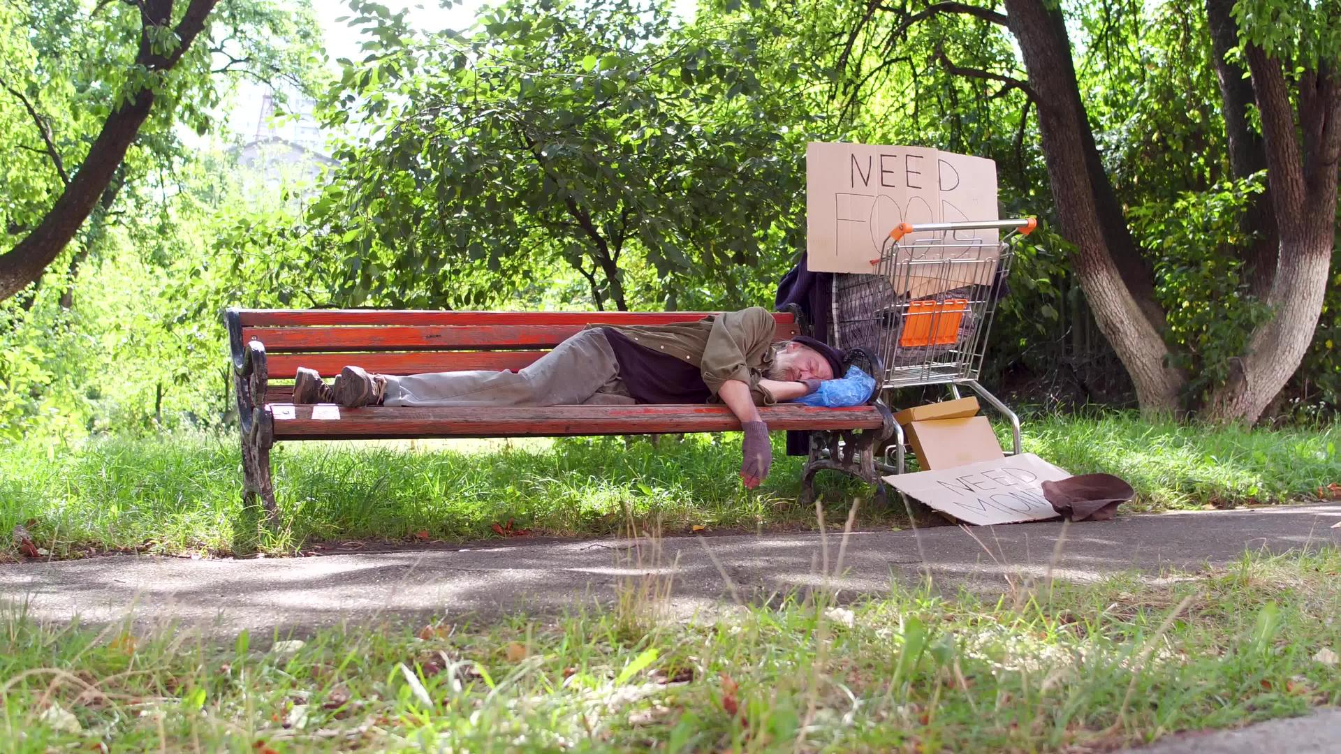 在城市公园的长椅上流浪的老人视频的预览图