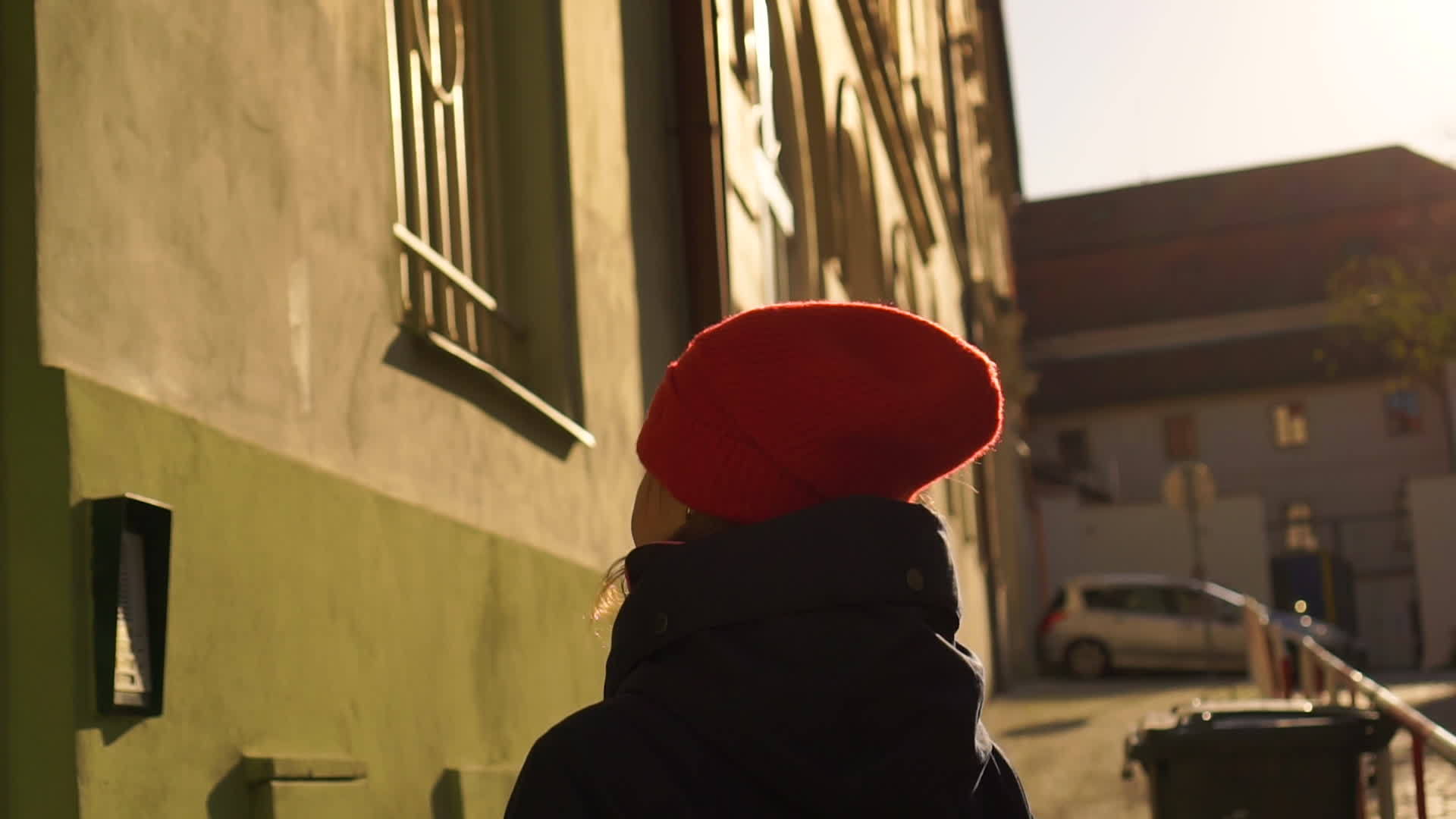 戴着红帽子的年轻女孩穿着红帽子走在欧洲的老街上视频的预览图