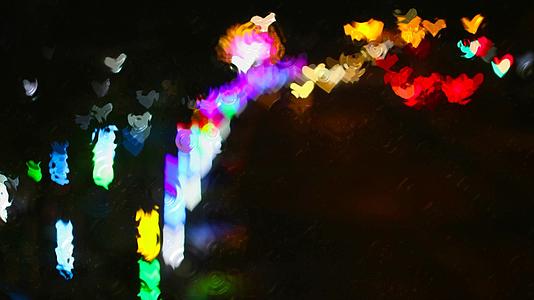 窗外雨玻璃地板上的水波街倒映着心形彩虹灯视频的预览图