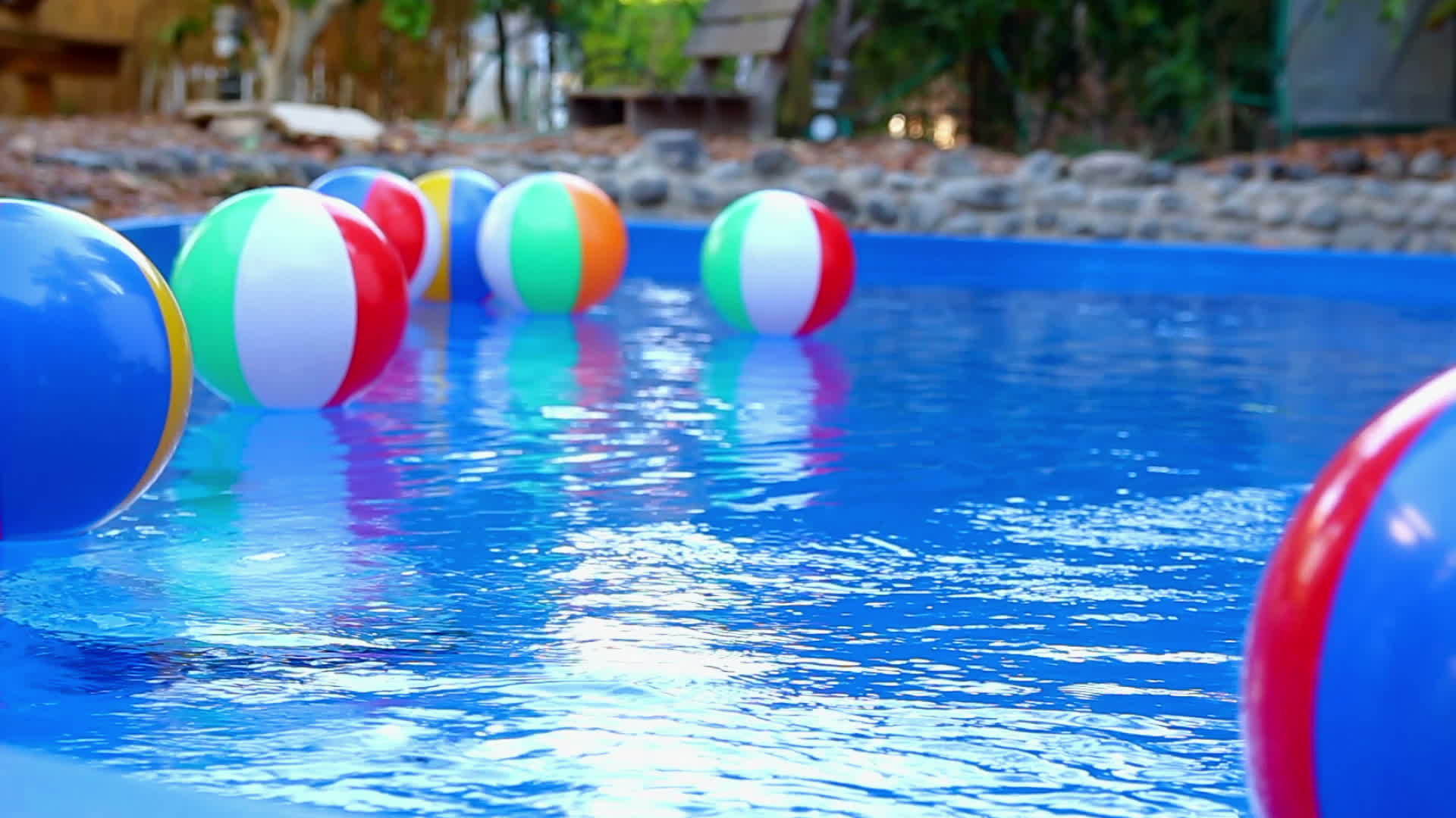 漂浮在游泳池中的彩色海滩球视频的预览图