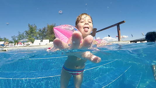 从水下看孩子们的手在冲浪温泉的水中微笑用舌头视频的预览图
