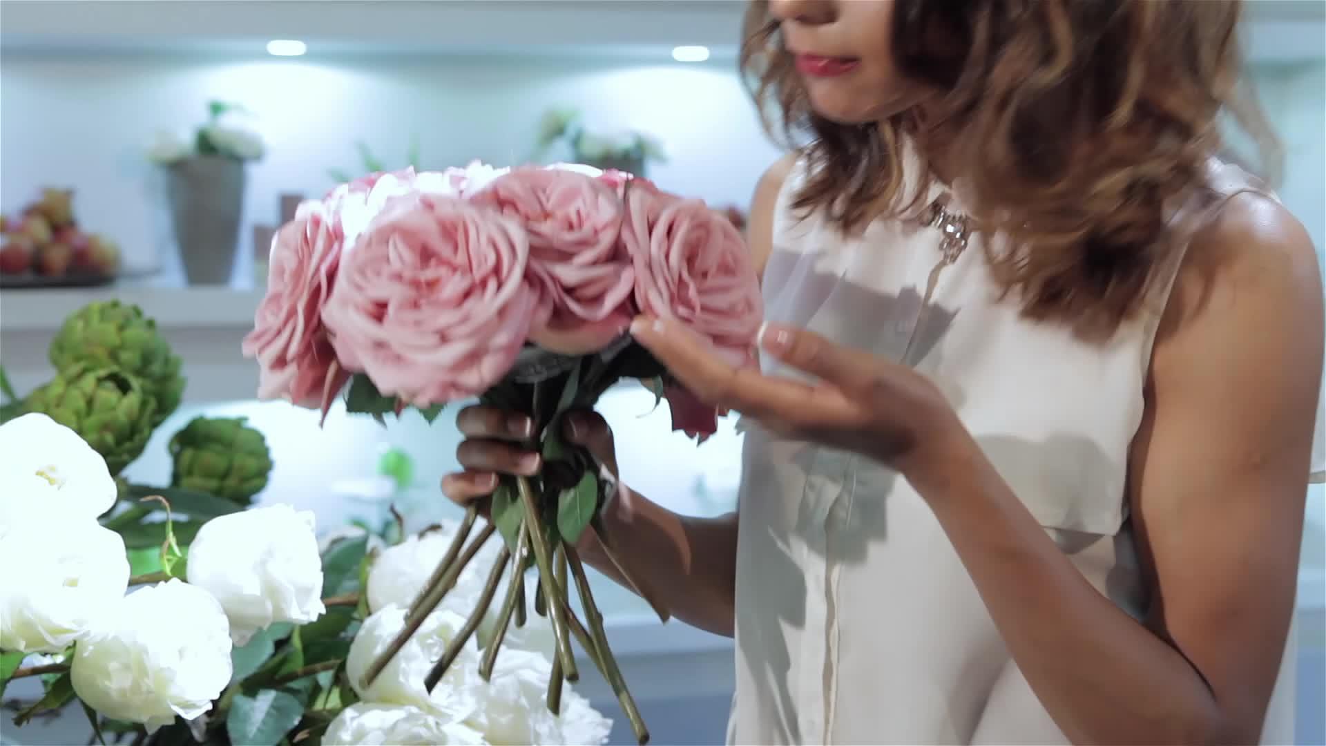 女人在花店吃一束粉红玫瑰视频的预览图