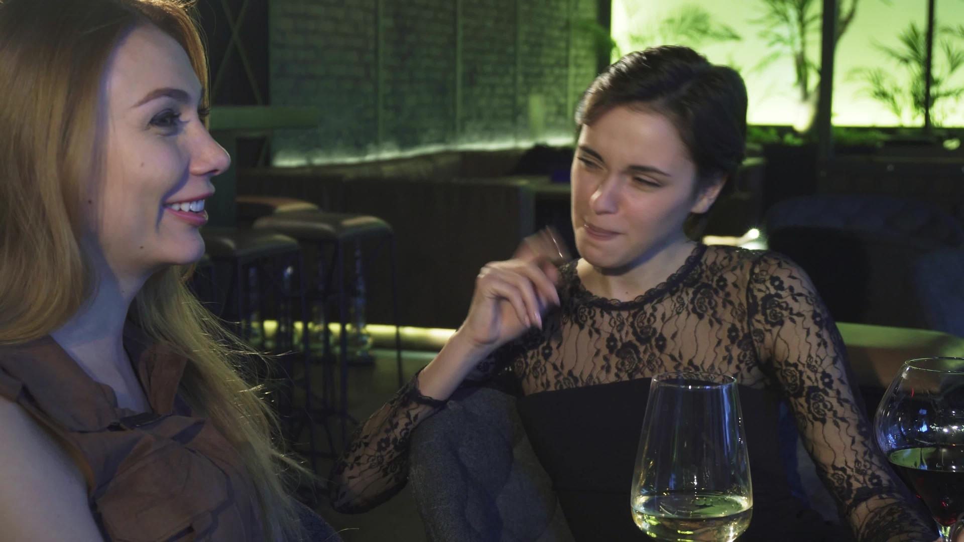 两个美丽快乐的女孩在酒吧里微笑着聊天喝酒视频的预览图
