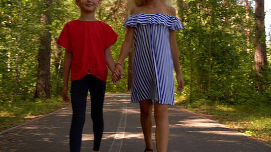 两个女朋友手牵着手在夏天的公园里快乐地视频的预览图