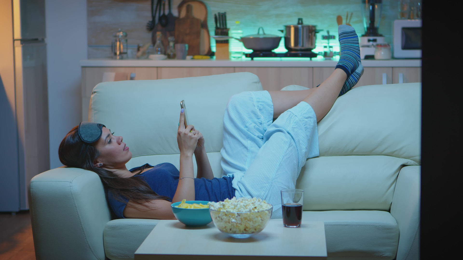女人躺在沙发上检查手机视频的预览图