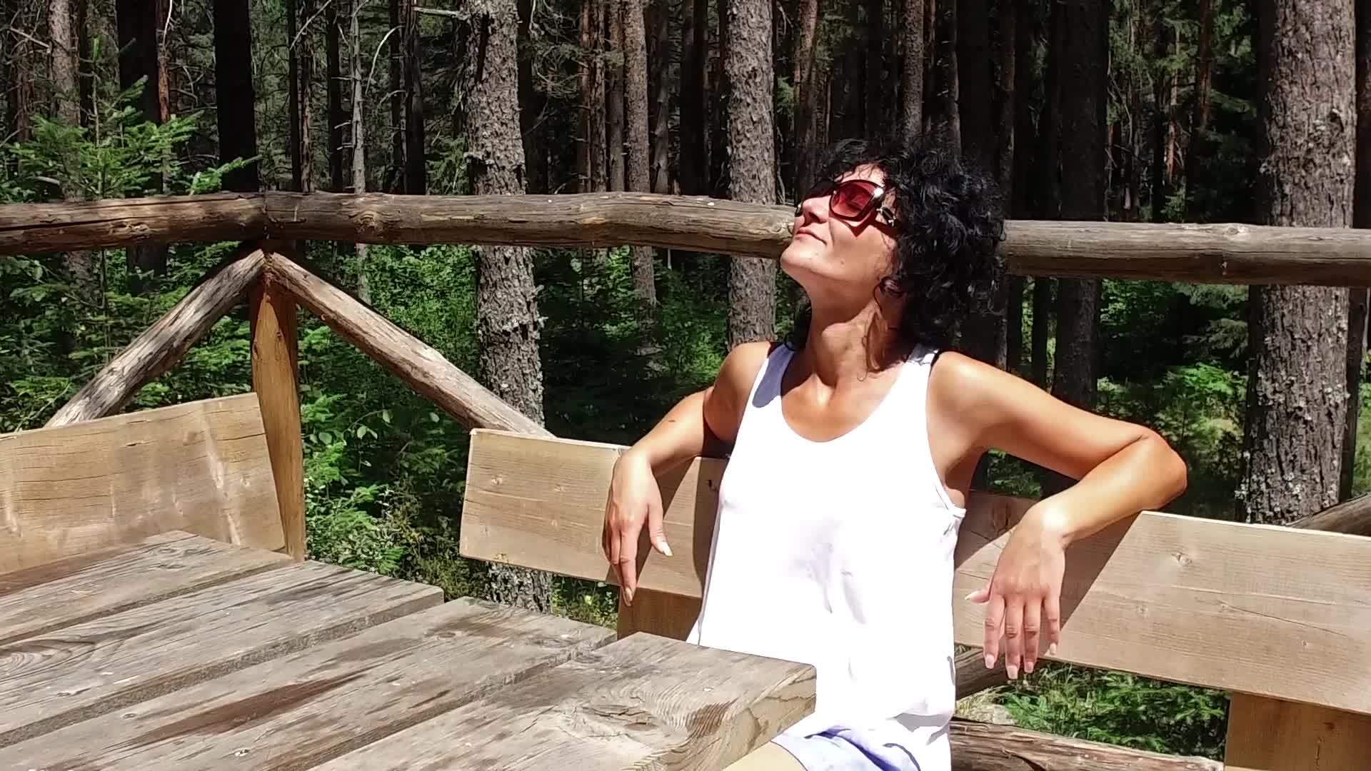 美丽的女孩模特喜欢坐在森林里的木屋阳台上视频的预览图