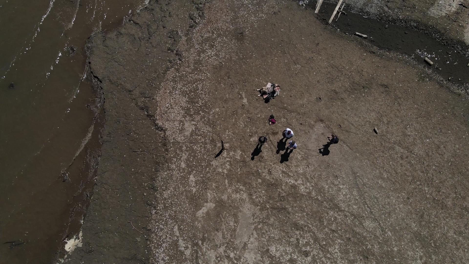 无人驾驶无人机降落在瑞士海滩五个人在寻找视频的预览图